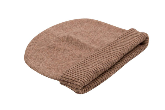 Auf dem Bild ist eine braune Beanie-Mütze aus Kaschmir zu sehen. Sie hat eine glatte Oberfläche und einen umgeschlagenen, gerippten Rand. Die Mütze liegt flach auf einer weißen Fläche. Es sind keine weiteren Gegenstände oder Muster zu erkennen, der Fokus liegt komplett auf der hochwertigen Kopfbedeckung. Die Farbe ist ein warmes Braun, das Material wirkt weich und edel.
